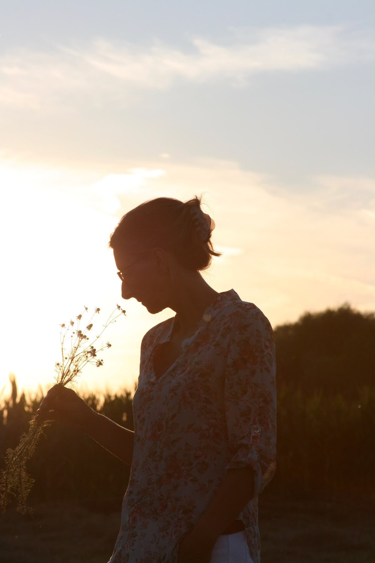 Anja Hoffmann mit Wildblumen als Silhouette im Abendlicht